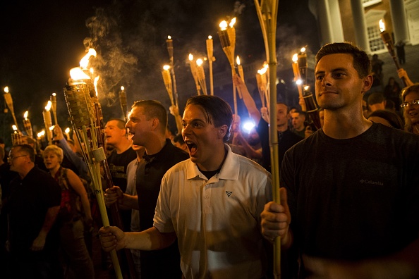 Neo Nazis, Alt-Right and White Supremacists encircle and chant at counter protesters at the base of a statue of Thomas Jefferson after marching through the University of Virginia campus with torches. (Photo by Samuel Corum/Anadolu Agency/Getty Images)