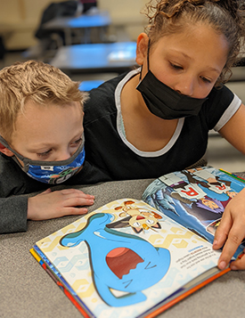 Out-of-school-time students coloring, wearing face masks.